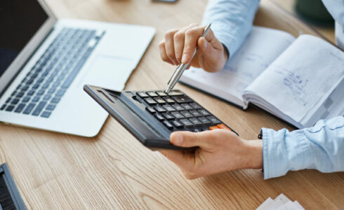 Photo d'une personne en train de calculer les déductions d'impôts pour la construction de sa maison neuve